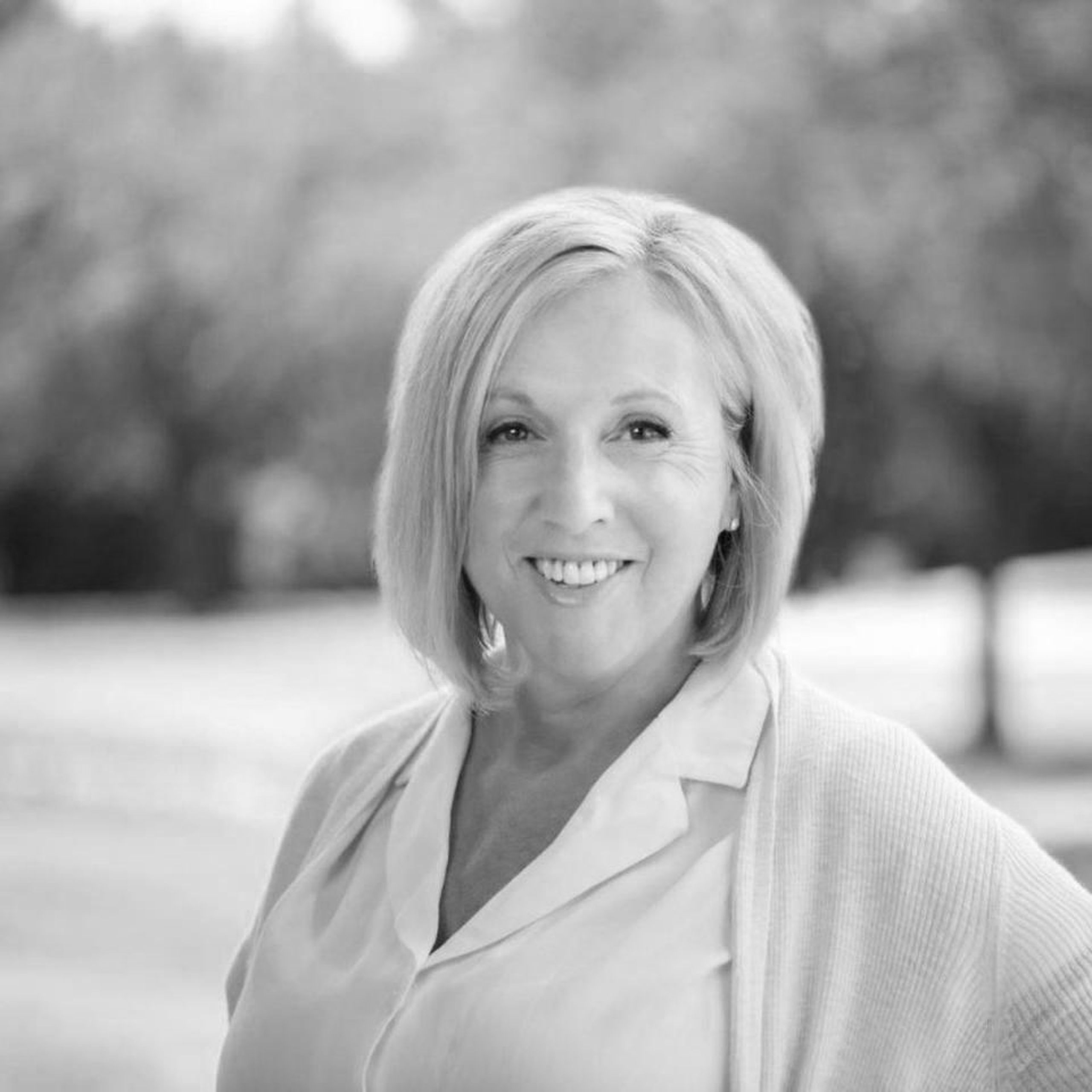 Black and white portrait of Mary Hotaling, Sales Manager at Ocotillo Golf Club, smiling warmly in an outdoor setting. With extensive experience in hospitality and event planning, Mary specializes in creating seamless and unforgettable wedding experiences at one of Arizona’s most scenic golf course venues.